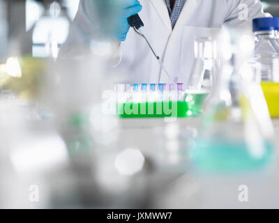 Scienziato il pipettaggio di campioni in provette eppendorf per test durante un esperimento in laboratorio Foto Stock