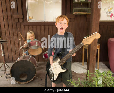 I bambini a suonare la chitarra e percussioni in banda Foto Stock