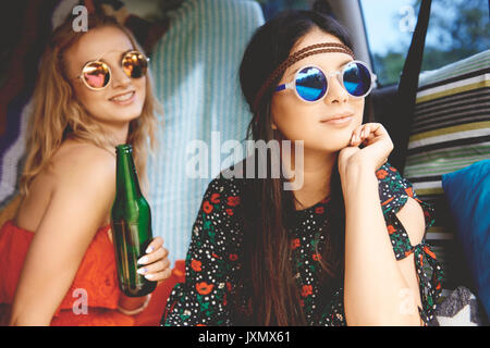 Due giovani donne boho indossando occhiali da sole in ricreativo van Foto Stock