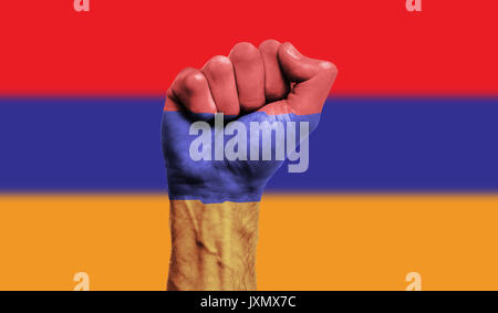 Bandiera dell'Armenia dipinta su un pugno chiuso. Forza, potenza, concetto di protesta Foto Stock