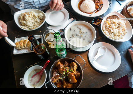 Legenda Leongs, Chinatown, Londra, piatti multipli sul tavolo pranzo compresa la birra, oyster congee ,riso fritto, maiale pancette, gnocco di pollo Foto Stock