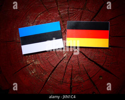 Bandiera estone con bandiera tedesca su un ceppo di albero isolato Foto Stock