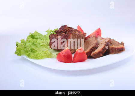 Bistecca di carne alla griglia con pomodoro, lattuga e fagioli melagrana sulla piastra bianca. Foto Stock