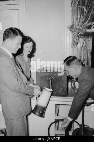 Beta Theta Pi, fraternità, vita studentesca Candid shot di fraternità membri riempiendo una birra stein e toccando un barile, 1947. Foto Stock