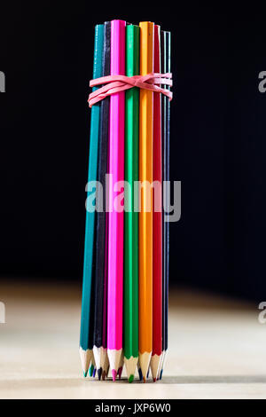 Bello e colorato matite. Un tavolo di legno. Sfondo nero. Foto Stock