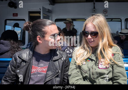 OAKLAND, ca- 13 maggio 2017: due hipster millennial parlando in traghetto da San Francisco a Oakland. Giacca di pelle, uomo bun, occhiali da sole, politico Foto Stock