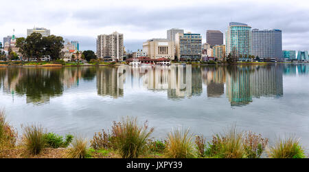 Oakland, la California il Centro Lago Merritt skyline. Piante in primo piano. Bella riflessioni. Vista sul lago. Foto Stock