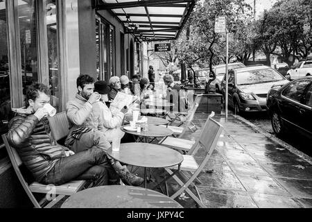 OAKLAND, LA CALIFORNIA-DEC 11, 2014: bevitori di caffè in un cafè sul marciapiede nel raffinato quartiere Rockridge, noto per le sue molte opzioni per il pranzo e la cena. Foto Stock
