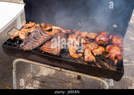 Il tradizionale 'Poulet Boucane' pollo affumicato e nervature di cottura barbecue in canna in Martinica Foto Stock