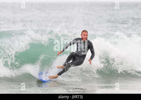 Metà maschio adulto cadere un'onda surf in Cornovaglia, England, Regno Unito Foto Stock