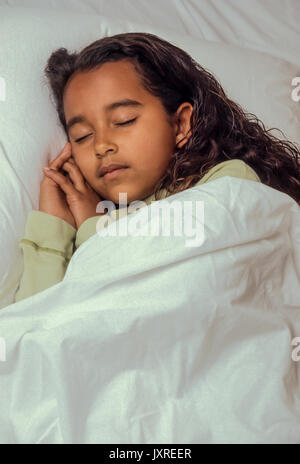 Andare a dormire per la giovane ragazza 7-10 anni dorme nel letto tranquillo African American/Caucasian Foto Stock