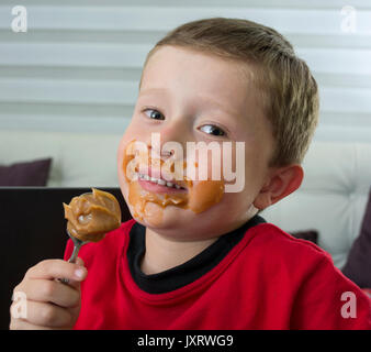 Ragazzo di mangiare il cioccolato a cucchiaio. Foto Stock