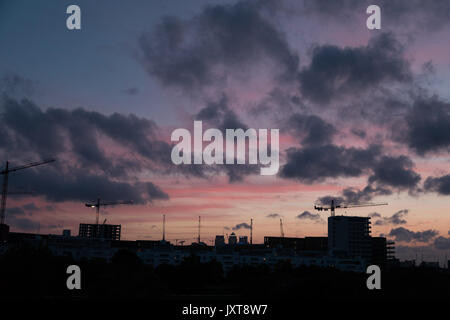 Silvertown, Newham, Londra, Regno Unito. 17 Ago, 2017. Regno Unito: Meteo Nuvoloso Tramonto rosa a Londra, Silvertown area. Un giorno asciutto è previsto. Riqualificazione estesa che si verificano con il Royal wharf Credito: WansfordPhoto/Alamy Live News Foto Stock