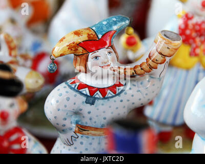 Desk al mercato delle pulci: tradizionale russo ceramica artigianale bambola clown uomo in costume russo suonare il clacson. Foto Stock