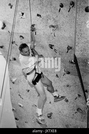 Michael Rubens Bloomberg, colpo candida, Bloomberg sta arrampicando una parete di arrampicata, ha scivolato e sta penzando da un imbracatura di sicurezza, circa 47 anni di età, 1997. Foto Stock