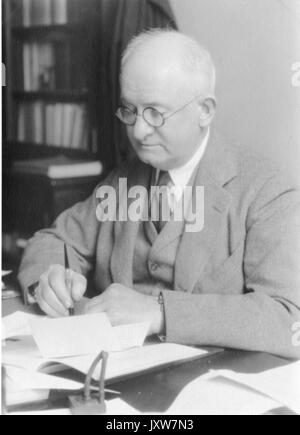 Joseph Sweetman Ames, Ritratto fotografico, seduta alla scrivania con la penna in mano, vita in alto, vista di tre quarti, 1930. Foto Stock