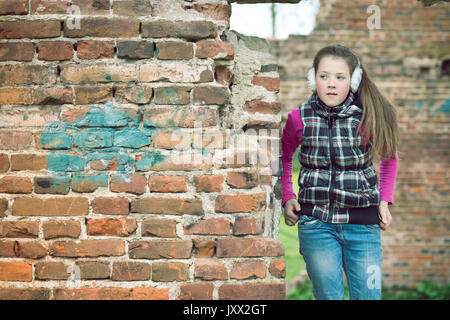 Ragazza adolescente in plaid vest giocando sulla costruzione di mattoni rovine Foto Stock