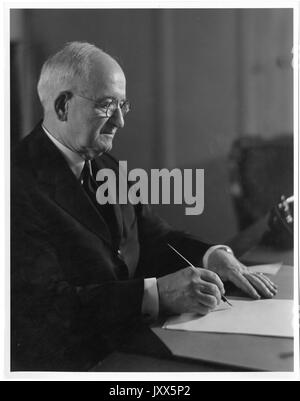 Joseph Sweetman Ames, Ritratto fotografico, seduta alla scrivania con la penna in mano, vita in alto, vista di tre quarti, 1930. Foto Stock