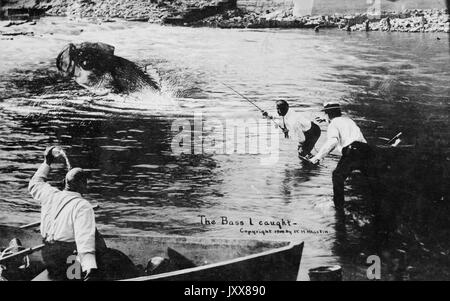 Due uomini afroamericani stanno guastando in acqua, cercando di catturare un basso di dimensioni superiori, mentre un terzo afroamericano è su una barca, tenendo un pesce, 1915. Foto Stock