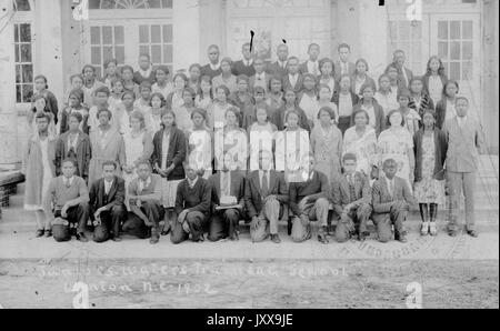 Ritratto a lunghezza intera di una classe co-ed di studenti neri con due insegnanti, tutti gli studenti che indossano uniformi; Winton, NC, 1920. Foto Stock