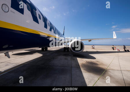 Piano di Ryanair su asfalto con passeggeri a piedi la porta posteriore, Aeroporto di Reina Sofia, Tenerife, Isole Canarie, Spagna Foto Stock