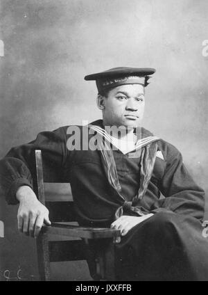 Ritratto di tre quarti di un marinaio della Marina militare americana Africana americana della prima guerra mondiale, seduto, in uniforme, espressione facciale neutra, 1920. Foto Stock