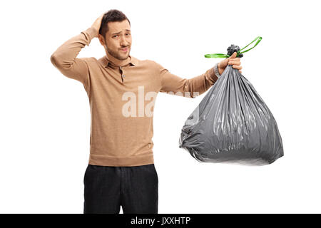 Giovane con un sacco di immondizia tenendo la sua testa in incredulità isolati su sfondo bianco Foto Stock