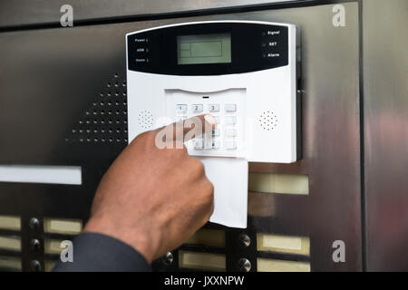 Close-up di commercianti la mano inserendo il codice nel sistema di sicurezza Foto Stock