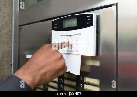 Close-up di commercianti la mano inserendo il codice nel sistema di sicurezza Foto Stock