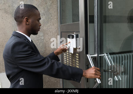 Giovane Imprenditore africano immettendo il codice nel sistema di sicurezza Foto Stock