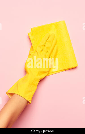 La donna di pulitura a mano su un sfondo rosa. La pulizia o la nozione di pulizie Foto Stock