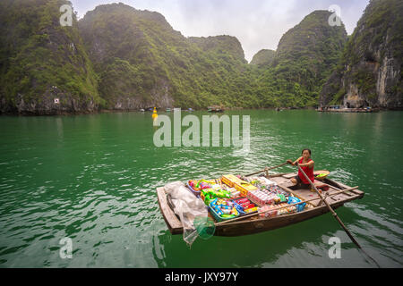 Tradizionale vietnamita fornitore in barca a vendere i prodotti su una barca di posta indesiderata nella baia di Halong, Vietnam Foto Stock