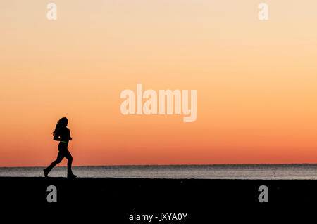 Argelès-sur-Mer (sud-est della Francia). Giovane donna jogging in riva al mare nelle prime ore del mattino Foto Stock