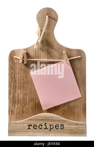Decorazioni in legno tagliere con un pezzo di carta appeso sul clothespins per la scrittura di prescrizioni isolati su sfondo bianco Foto Stock