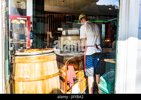 Bar Harbor, Stati Uniti d'America - 8 Giugno 2017: primo piano della fresca pizza artigianale nel panificio negozio sul display dalla finestra con chef di lavoro dei dipendenti Foto Stock