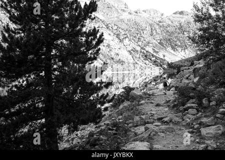 Ragazzo che guarda al lago e monti foto con la riflessione Foto Stock