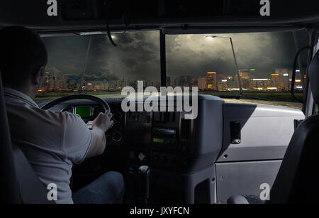 Il driver è un carrello elevatore con un carico nella città di notte. viaggio di lavoro Foto Stock