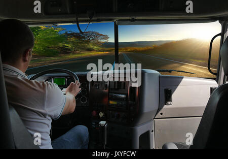 Il camionista sulla strada tra campi autostrada. viaggio di lavoro Foto Stock