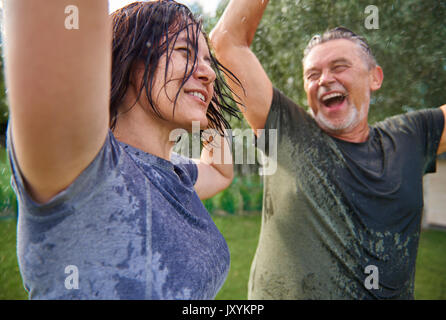 Coppia di anziani ballare sotto la pioggia Foto Stock