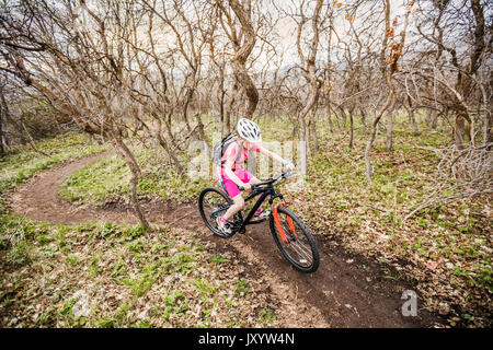 Ragazza caucasica equitazione Bicicletta sul sentiero forestale Foto Stock