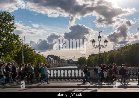 Persone attraversano il ponte O'Connell attraverso il fiume Liffey nella capitale irlandese di Dublino Foto Stock