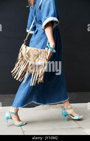 Sezione bassa di una donna in boho abito in denim e sfrangiato in borsa Foto Stock