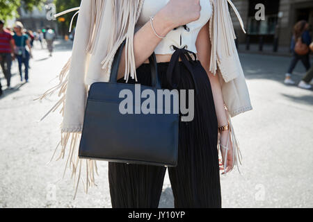 La donna in un frange camicia color crema e nero borsa in pelle Foto Stock