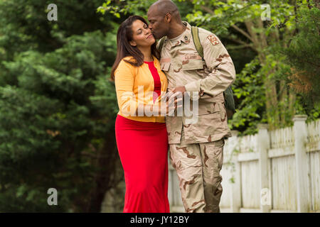 African soldato americano baciando la moglie sulla guancia Foto Stock