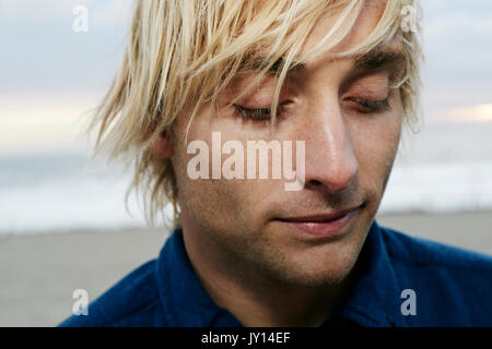 Ritratto di pensieroso uomo caucasico presso la spiaggia Foto Stock