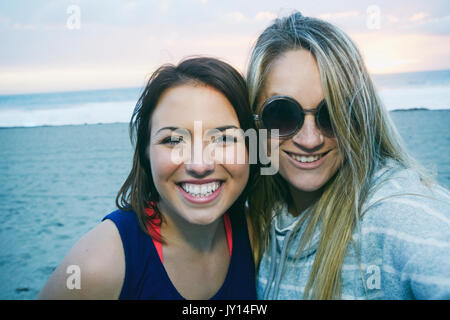 Ritratto di sorridente donne caucasiche in spiaggia Foto Stock