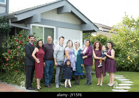 Multi-famiglia di generazione in posa vicino casa Foto Stock