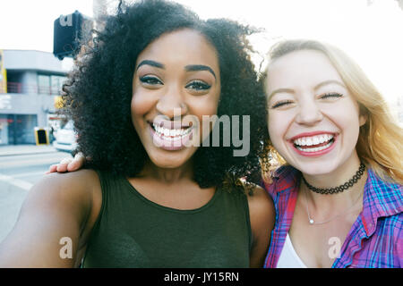 Amici in posa per selfie in città Foto Stock