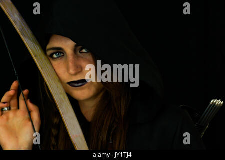 Una giovane donna vestita come un elfo con un cambio di legno arco e frecce Foto Stock