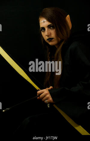 Una giovane donna vestita come un elfo con un cambio di legno arco e frecce Foto Stock